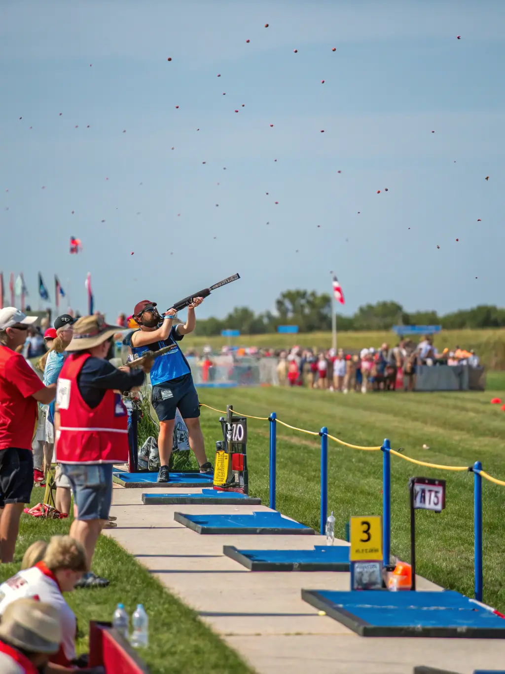 A photograph of a clay pigeon soaring through the air, just after being launched from the trap, with a shotgun aimed in its direction, capturing the dynamic moment of the sport.